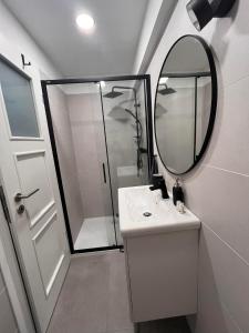 uma casa de banho com um chuveiro, um lavatório e um espelho. em Central Studio em Pécs