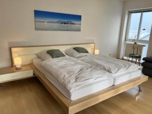 a large white bed in a room with a window at DG-Wohnung in Waldkraiburg 50qm in Waldkraiburg