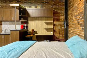 a bedroom with a bed and a brick wall at TwoSpaces Living at Pondok Pakde, Jogja in Soprayan