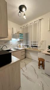 a white kitchen with marble floors and a light fixture at Apartament "NADIA" na Starym Rynku in Zielona Góra