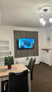 a dining room with a table and a tv on a wall at Apartament "NADIA" na Starym Rynku in Zielona Góra
