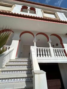 biały budynek ze schodami i balkonem w obiekcie Paraíso Mediterráneo w mieście Sueca