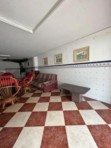 a room with a checkered floor with a couch and a table at Paraíso Mediterráneo in Sueca