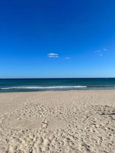 plaża z odciskami stóp w piasku i oceanie w obiekcie Paraíso Mediterráneo w mieście Sueca