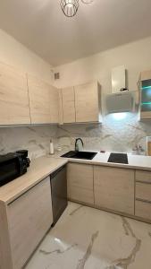 a kitchen with white cabinets and a sink in it at Apartament "NADIA" na Starym Rynku in Zielona Góra