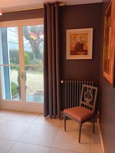 a room with a chair and a sliding glass door at coté remparts in Provins