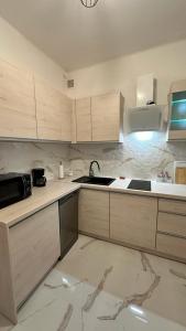 a kitchen with white cabinets and a sink and a stove at Apartament "NADIA" na Starym Rynku in Zielona Góra