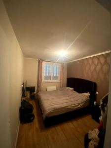 a bedroom with a bed and a light on the ceiling at 2 chambres avec vue sur Lyon in La Mulatière