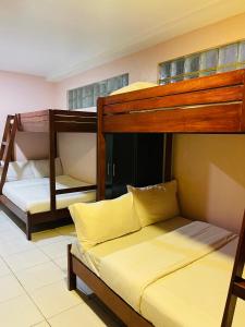 two bunk beds in a room with yellow sheets at Sukhavati Inn in Baguio