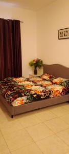 a bedroom with a bed with a floral comforter at Awesome studio at silicon oasis in Dubai