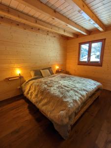 Cette chambre en bois comprend un grand lit. dans l'établissement Chalet Adler, à Saas-Fee
