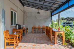 a dining room with wooden tables and chairs at Lightplus Khao Lak in Khao Lak