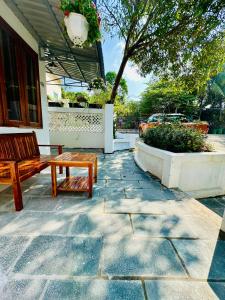 a wooden bench sitting on a stone patio at Vida Loca Sunset Beach Resort in Phu Quoc