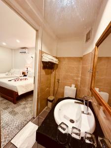 een badkamer met een wastafel, een douche en een bed bij Vida Loca Sunset Beach Resort in Phu Quoc