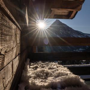 une chambre avec un tas de fourrure en face d'une montagne dans l'établissement Chalet Adler, à Saas-Fee