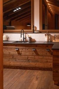 a kitchen with a sink and wooden cabinets at Chalet Adler in Saas-Fee