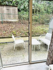 a sliding glass door with two chairs on a patio at Sophisticated City Loft in Mainz