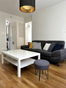 a living room with a white coffee table and a couch at Appartement 6 places, 3 chambres in La Mulatière