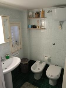 een badkamer met een wit toilet en een wastafel bij Camera Brupier in Ruvo di Puglia