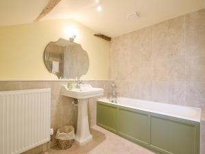 a bathroom with a sink and a tub and a mirror at Malabar House in Lyme Regis +47 photos