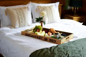 a tray of breakfast in bed on a bed at Cabana Bavareză in Porumbacu de Sus