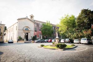 a building with a statue in the middle of a street at Casa San Brasi di Mariano e Lucia in Acireale