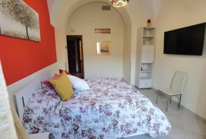 a bedroom with a bed and a flat screen tv at Casa San Brasi di Mariano e Lucia in Acireale