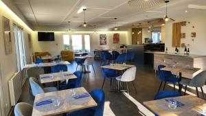 a restaurant with wooden tables and blue chairs at Kyriad Bellegarde - Genève in Bellegarde-sur-Valserine