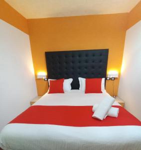a bedroom with a large bed with red pillows at Hotel Veronese in Genova