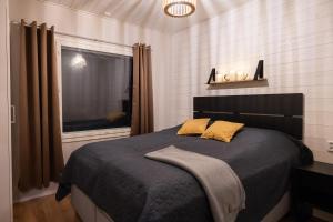 a bedroom with a large bed with a window at Villa Blueberry in Rovaniemi