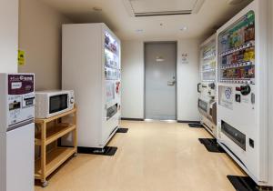 a kitchen with a refrigerator and a microwave at Daiwa Roynet Hotel Mito in Mito