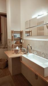 a bathroom with a white sink and a shelf at APPARTAMENTO LA SPIAGGETTA in Foligno