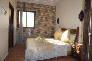 um quarto com uma cama e uma parede de tijolos em Riad Andalousse em Meknès
