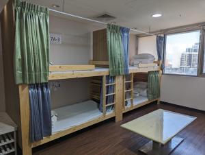a room with bunk beds with a window at Hey Bear Capsule Hotel in Taipei