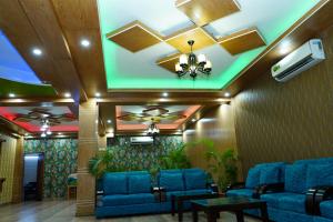 a lobby with blue couches and a ceiling at Garden Residents Uttara - Lake View in Dhaka