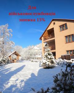 a snow covered yard in front of a building at Купецький Двір in Mizhhirʼʼya