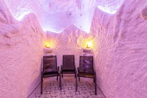 twee stoelen in een ijskamer met paarse muren bij Konopka Forest Home & SPA in Boekovel