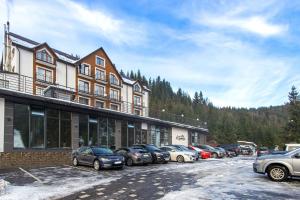 uma fila de carros estacionados em frente a um edifício em Konopka Forest Home & SPA em Bukovel