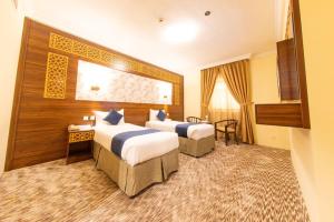 Postel nebo postele na pokoji v ubytování Abraj Al Tayseer Tuwa Hotel