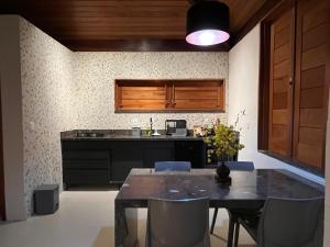 a kitchen with a table with chairs and a kitchen with a counter at Quinta do Sossego in Mata de Sao Joao
