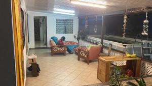 sala de estar con 2 sillas y mesa en Ravehei smile papeete punaauia en Papeete