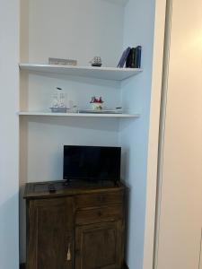 a tv on a wooden cabinet in a room at Monolocale La Conchiglia in Sestri Levante +5 photos