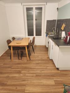 cocina con mesa de madera y sillas y cocina con fregadero en Plein centre, en Malzéville