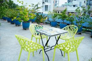une table, des chaises et des plantes en pot sur une terrasse dans l'établissement Garden Residents Uttara - Lake View, à Dhaka