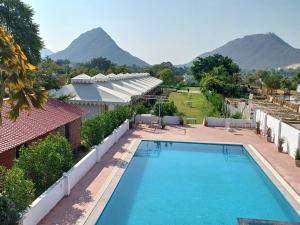 une piscine avec des montagnes en arrière-plan dans l'établissement Royal Pushkar Camps- a Luxury Camp Resort, à Pushkar