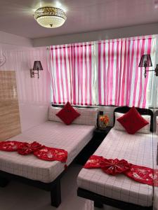 two beds in a room with red bows on them at Manila Lounge in Hong Kong