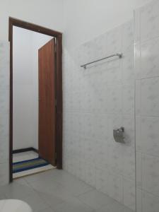 uma casa de banho com um chuveiro e uma porta de vidro em Golden Beach Guest House and Restaurant em Hikkaduwa
