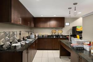 cocina con armarios de madera y encimera en Residence Inn Neptune at Gateway Center, en Neptune City