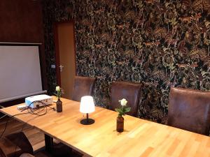a meeting room with a table and chairs and a screen at Parkhotel Schotten in Schotten