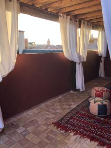 a room with a large window with curtains and a rug at Riad Paquerette in Marrakesh